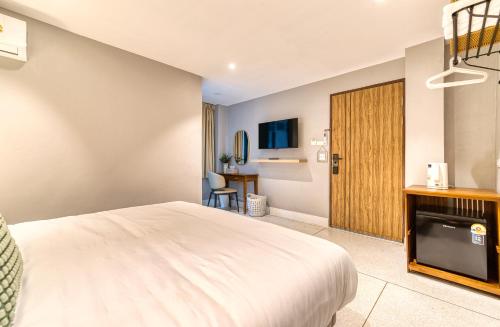 a hotel room with a bed and a television at AB House in Bangkok