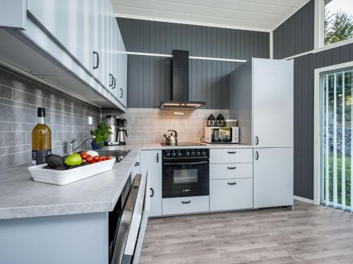 a kitchen with white appliances and a bowl of fruit at Holiday Home Skuta by Interhome in Korssund