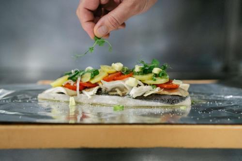 a person holding a piece of food on a table at Hotel-Restaurant-Vinothek Felix Sommer in Auersthal
