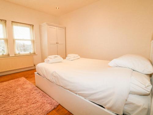 a bedroom with a white bed with two towels on it at 6 Fidlers Close in Bamford