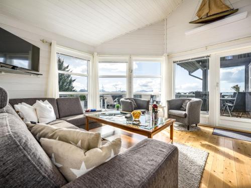 a living room with couches and a table at Holiday Home Sjøbuvågen by Interhome in Korssund