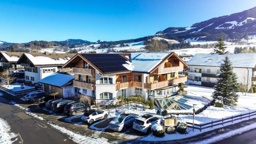 an aerial view of a house with cars parked in a parking lot at VILLAWILLI - Gemütliche Ferienwohnungen in Fischen
