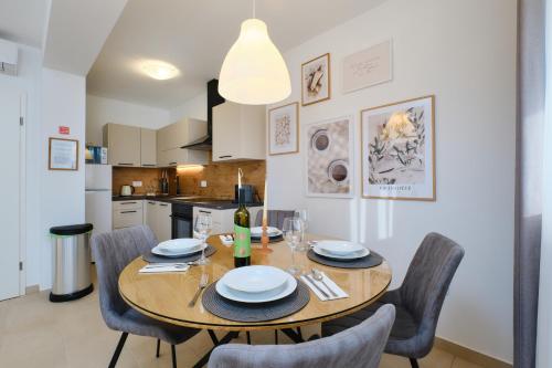 a kitchen and dining room with a table and chairs at Apartments Divna in Mali Lošinj