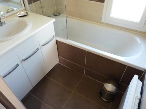 une salle de bain avec une baignoire blanche et un lavabo dans l'établissement Charmante Villa 4 pers piscine terrasse 600 m de la plage, à Belgodère