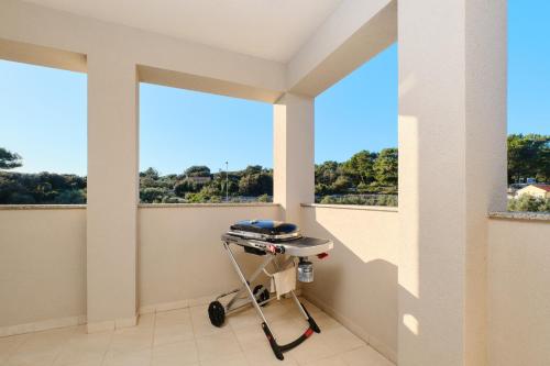 a room with two windows and a cart in front of it at Apartments Divna in Mali Lošinj
