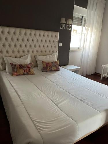 a large white bed with two pillows on it at Rio Maior Hotel in Rio Maior