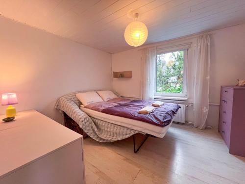 a small bedroom with a bed and a window at GreenHill House in Kaunas
