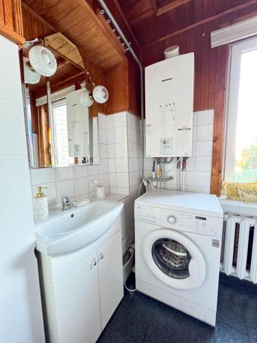 a bathroom with a washing machine and a sink at GreenHill House in Kaunas