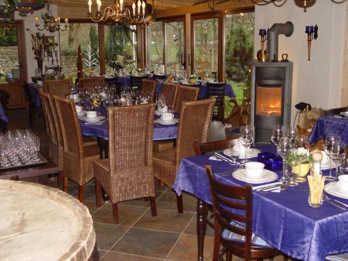 a dining room with blue tables and chairs and a fireplace at Altes Zollhaus Nähe Luxemburg in Ammeldingen