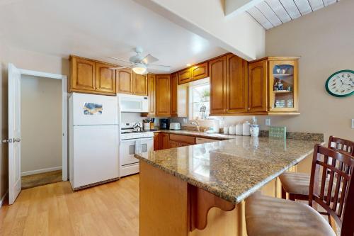 a kitchen with wooden cabinets and a white refrigerator at Dancing Bear Chalet in Lake Arrowhead