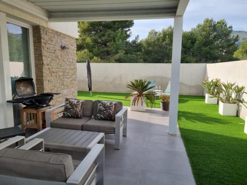 a patio with a couch and a tv and grass at Casa Vistas al Mar en Alcossebre in Alcossebre