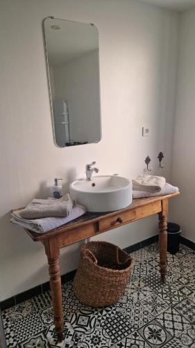 une salle de bain avec un lavabo et un miroir dans l'établissement Le blason, à Rosult