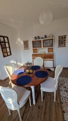 une salle à manger avec une table en bois et des chaises blanches dans l'établissement Le blason, à Rosult
