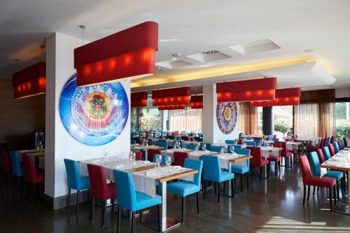 a dining room with tables and blue chairs at Crowne Plaza Verona Fiera by IHG in Verona