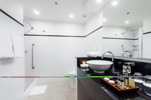 a bathroom with a sink and a mirror at Tequendama Suites Bogota in Bogotá