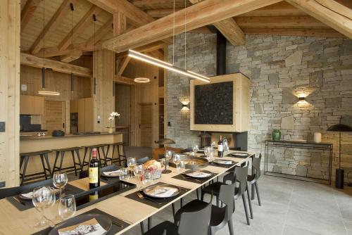 une salle à manger avec une longue table et des chaises dans l'établissement Odalys Chalet L'Hermine, à Les Deux Alpes