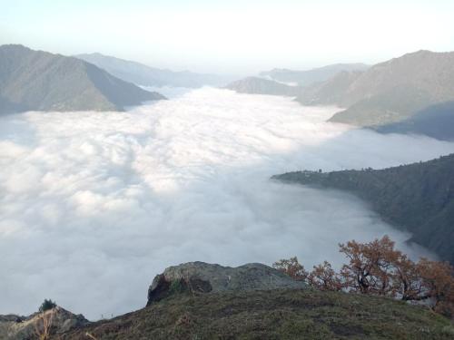 a view of a sea of clouds in the mountains at Hima 360 Vistaview Mountain Cabin, Bhatkanda in Sainj