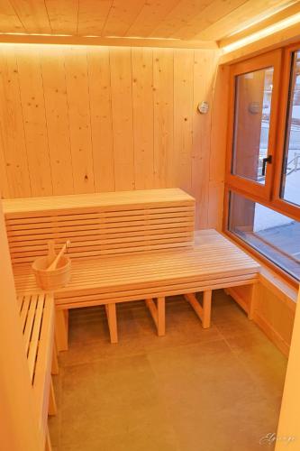 a wooden bench in a room with a window at Chalet Jean (Coeur de Morzine) Jacuzzi & Sauna in Morzine