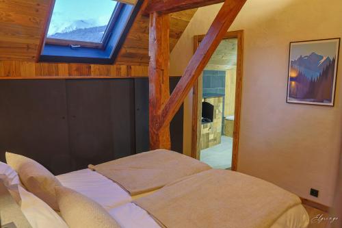 a bedroom with a large bed with a window at Chalet Jean (Coeur de Morzine) Jacuzzi & Sauna in Morzine