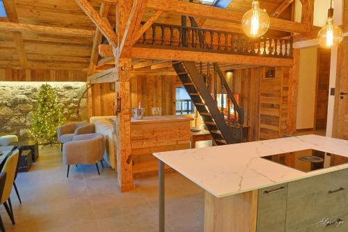a kitchen and living room with a staircase in a cabin at Chalet Jean (Coeur de Morzine) Jacuzzi & Sauna in Morzine