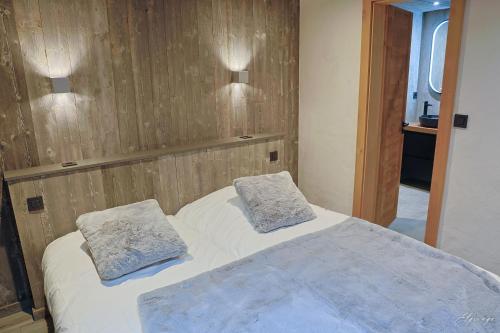 a bedroom with a bed with two pillows on it at Chalet Jean (Coeur de Morzine) Jacuzzi & Sauna in Morzine