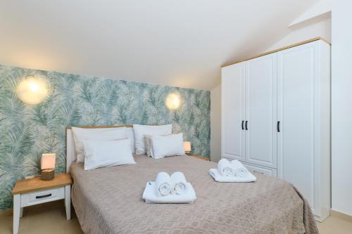 a bedroom with a bed with two towels on it at Apartments Divna in Mali Lošinj