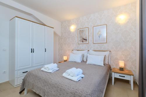 a bedroom with a bed with two towels on it at Apartments Divna in Mali Lošinj