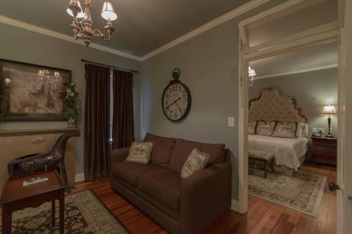 a living room with a couch and a clock on the wall at The Campbell Hotel in Tulsa