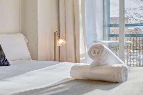 A bed or beds in a room at Mirasierra Suites Pamplona