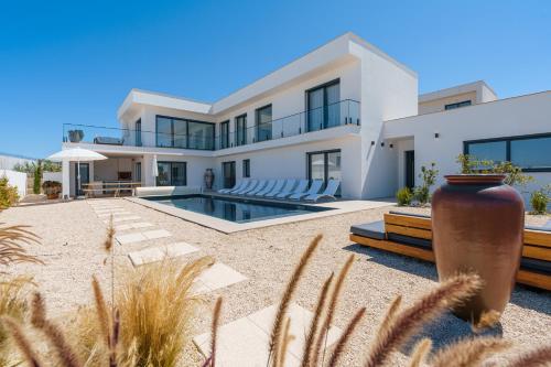 a villa with a swimming pool in the desert at Casa Evangeline, luxury villa with ocean view in Lourinhã