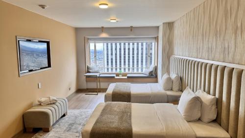 a hotel room with two beds and a window at Tequendama Suites Bogota in Bogotá