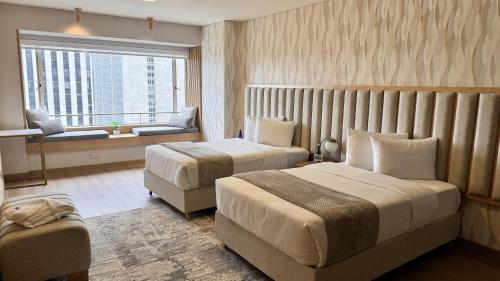a hotel room with two beds and a window at Tequendama Suites Bogota in Bogotá