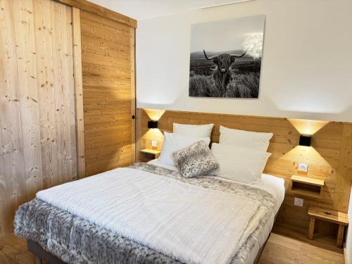 - une chambre dotée d'un lit avec une photo de taureau dans l'établissement Appartement moderne aux Gets avec parking et WIFI proche centre - FR-1-623-133, aux Gets
