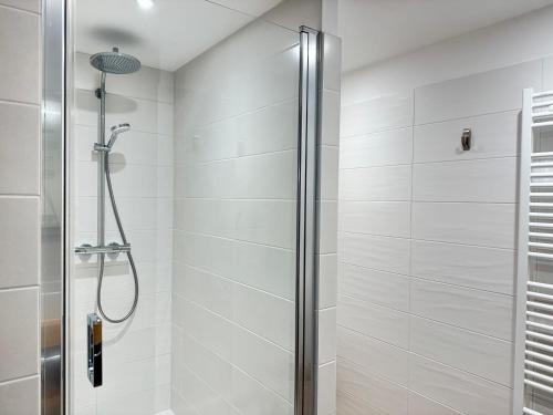 une douche avec une porte vitrée dans une salle de bain dans l'établissement Appartement moderne aux Gets avec parking et WIFI proche centre - FR-1-623-133, aux Gets