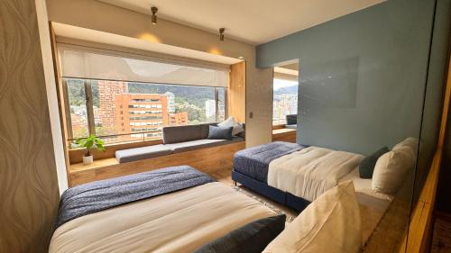 a bedroom with two beds and a large window at Tequendama Suites Bogota in Bogotá