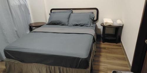 Una cama en una habitación pequeña con un teléfono al lado. en Relax in Paradise Boracay Island, en Boracay