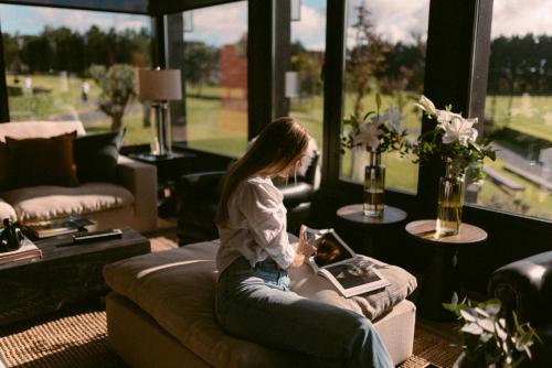a young girl sitting on a couch in a living room at Haras Santa María del Mar in Mar del Plata