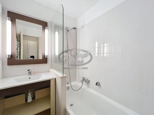 ein weißes Badezimmer mit Waschbecken und Dusche in der Unterkunft Appartement 4 personnes vue mer résidence pierre et vacances à Pramousquier in Rayol-Canadel-sur-Mer