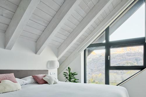 a bedroom with a bed and a large window at Casa de la paz en el Valle de Tena in Sandiniés