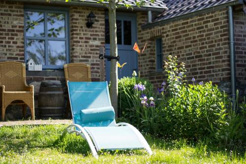 a blue chair in the yard of a house at Huize Mesch in Eijsden