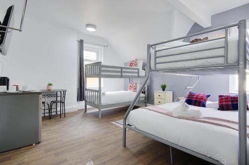 a bedroom with two bunk beds and a desk at Azure Beach Hotel in Bournemouth