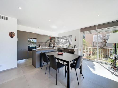 une cuisine et une salle à manger avec une table et des chaises dans l'établissement Magnifique appartement moderne en duplex 4 personnes avec terrasse et chambres vue mer à la Fossette - Le Lavandou, au Lavandou