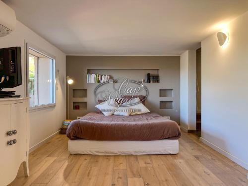 une chambre avec un lit avec un panneau sur le mur dans l'établissement Magnifique appartement moderne en duplex 4 personnes avec terrasse et chambres vue mer à la Fossette - Le Lavandou, au Lavandou