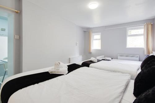 two beds in a room with white and black at Azure Beach Hotel in Bournemouth