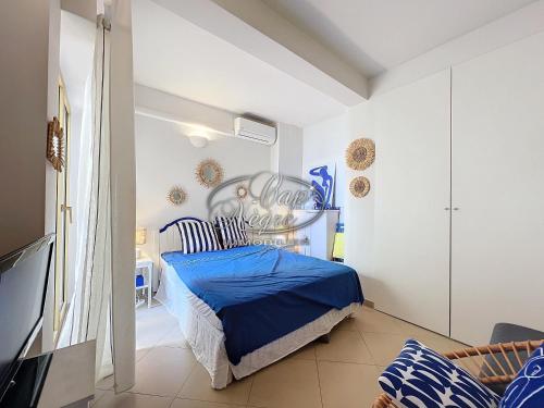 - une chambre avec un lit bleu dans l'établissement Appartement T2 vue mer, pieds dans l'eau avec accès direct à la plage de Cavalière - LE LAVANDOU, au Lavandou