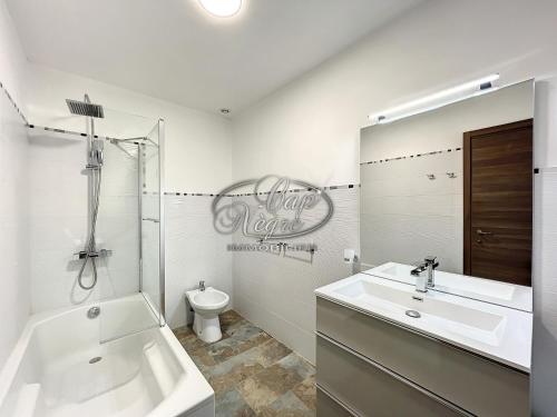 une salle de bain avec un lavabo, une baignoire et des toilettes dans l'établissement Villa pieds dans l'eau pour 10 personnes avec port privé et rooftop à Cavalière, au Lavandou