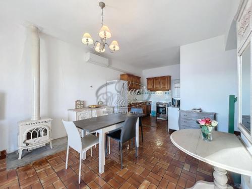 une cuisine avec une table, des chaises et une cuisinière dans l'établissement Maison vue mer pour 8 personnes au Rayol, à Rayol-Canadel-sur-Mer