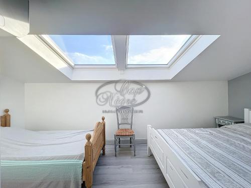 une chambre mansardée avec deux lits et une lucarne dans l'établissement Maison vue mer pour 8 personnes au Rayol, à Rayol-Canadel-sur-Mer