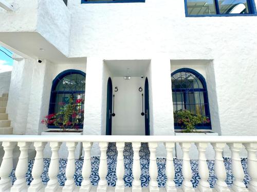 a white house with a white door and two windows at Villa kalah in Puerto Triunfo