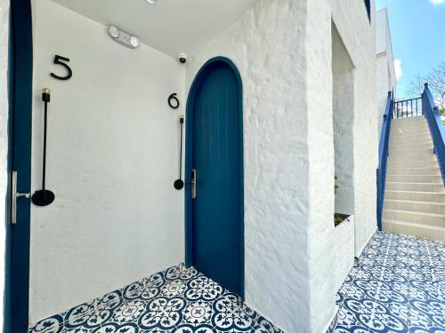 a blue door on a white wall with a tile floor at Villa kalah in Puerto Triunfo